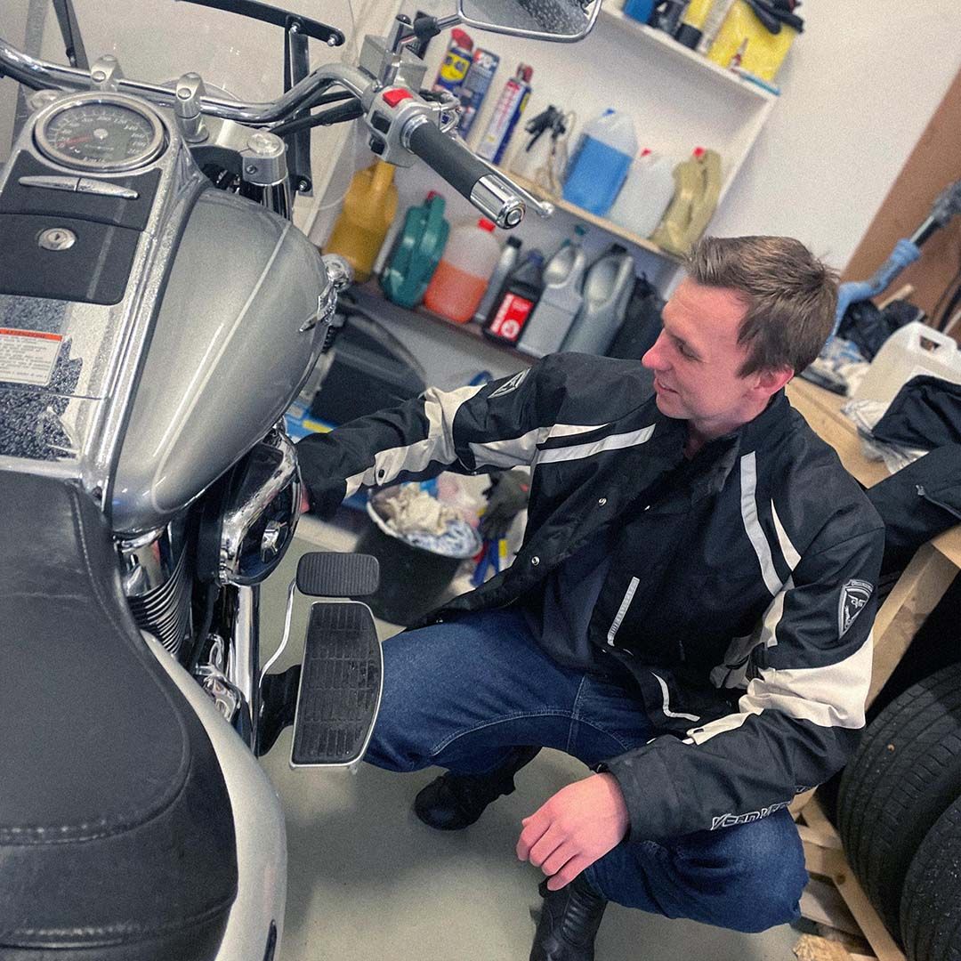 Daniel på Devize i grarage med sin motorcykel