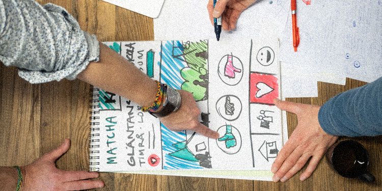 UX-designers pekar på stor handritad skiss i ritblock